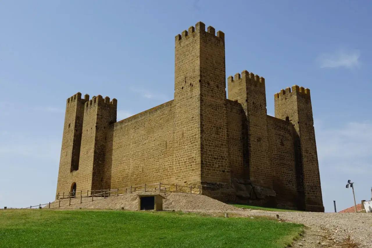 Imponente fortaleza de piedra, uno de los castillos de Aragón, se alza majestuoso bajo un cielo azul.