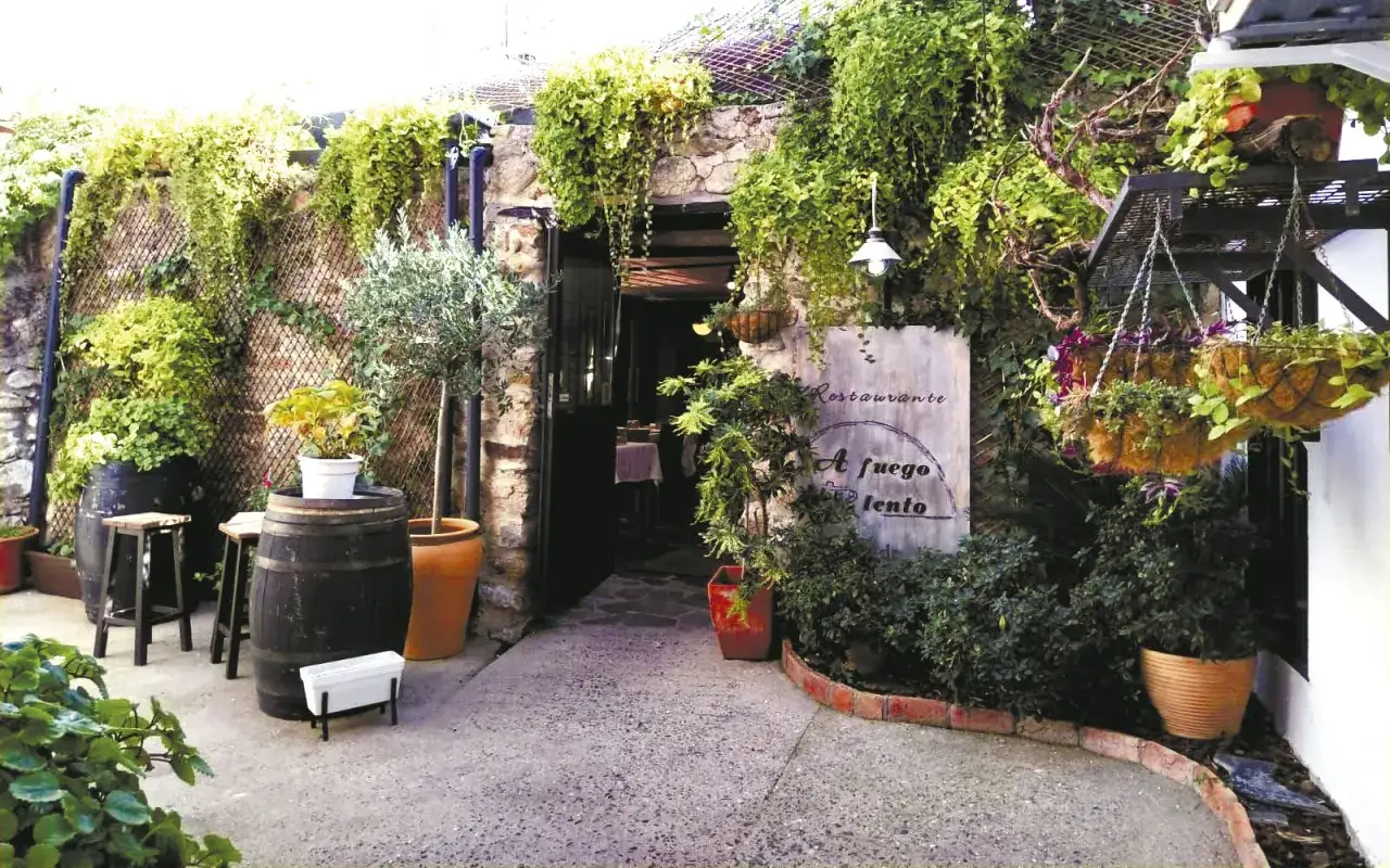 Entrada a un restaurante con mucha vegetación. Ideal para saber donde comer en Hervás.
