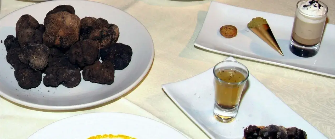 Platos exquisitos para comer en Morella: trufas negras, un shot de consomé y un postre en copa.