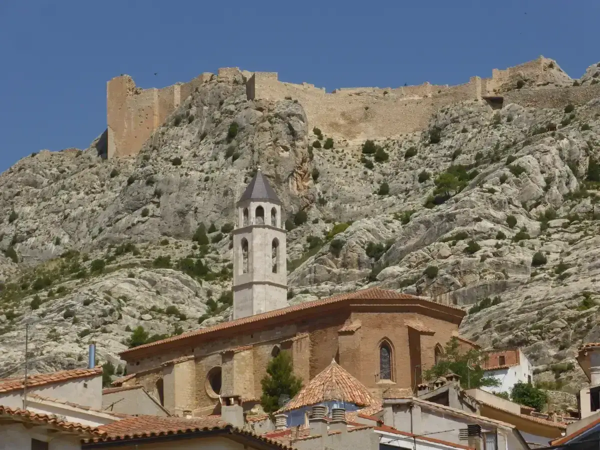 Iglesia y castillo en la ladera rocosa, con vistas de mas de las matas.