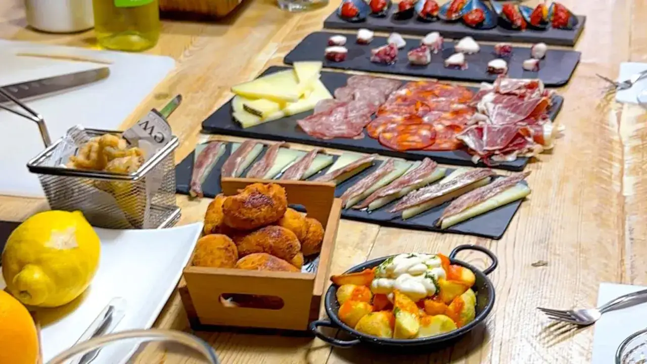 Variedad de tapas: calamares, patatas bravas, embutidos y quesos. ¡Una excelente opción para saber dónde comer en Barcelona!