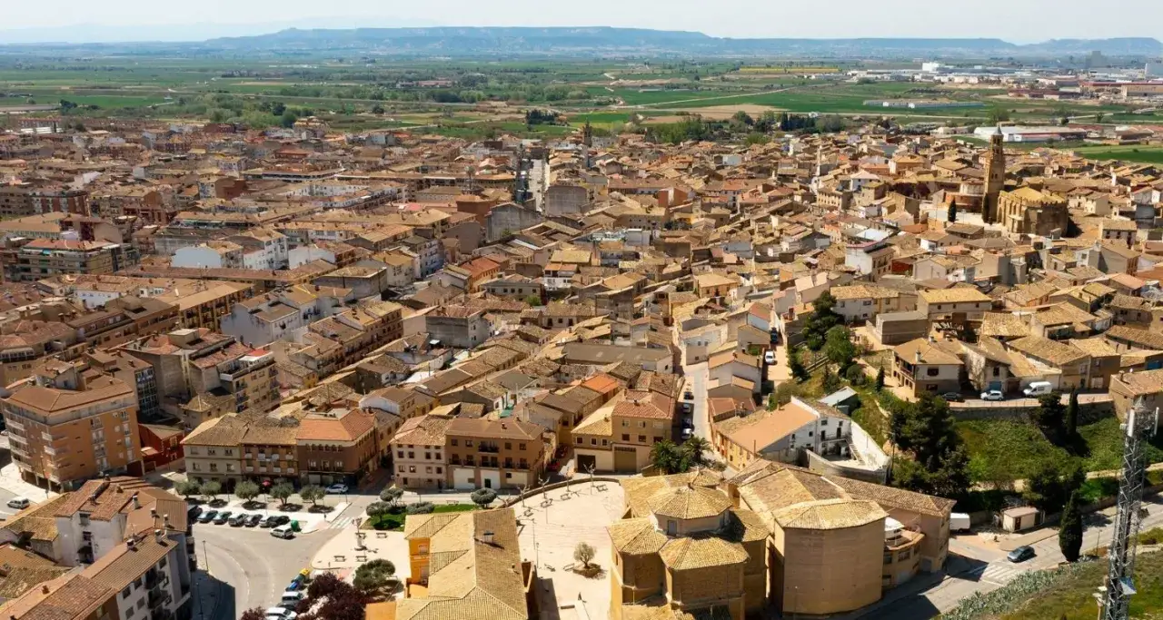Vista a&eacute;rea de un pueblo espa&ntilde;ol con tejados de teja, donde la ejea de los caballeros se extiende hasta el horizonte.
