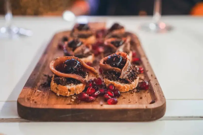 Deliciosos pinchos con anchoa, aceituna y granada, perfectos para comer en Burgos.